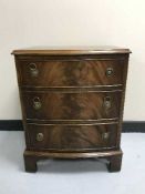 A mahogany three drawer chest on bracket feet and brass drop handles