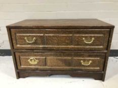 A low oak two drawer chest with brass drop handles