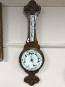 A carved oak aneroid barometer