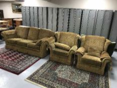 A three piece lounge suite in gold print