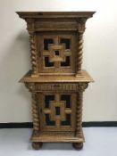 An early 20th century carved oak double door cabinet with barley twist supports