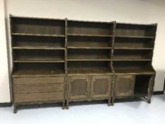 A triple section oak bookcase fitted cupboards