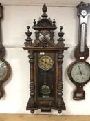 A Victorian wall clock with enamel dial