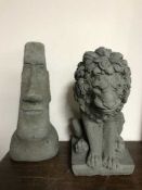 A garden Easter Island head and a garden lion figure