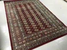 A contemporary Bokhara style rug on red ground