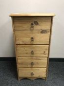 A pine narrow five drawer chest