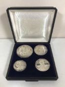 A set of four cased silver coins