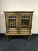 A continental oak sideboard with leaded glass doors