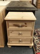 A pine three drawer bedside chest