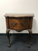 A walnut shaped front cabinet on claw and ball feet