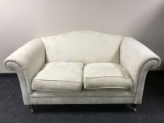 A Laura Ashley two seater scroll arm settee in a cream floral fabric