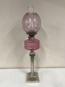 A Victorian Corinthian column oil lamp with pink glass shade