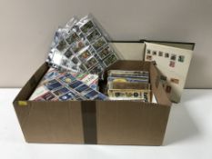 A box of three stamp albums and stamps and assorted books of cigarette cards