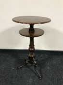 A circular mahogany wine table on cast metal legs