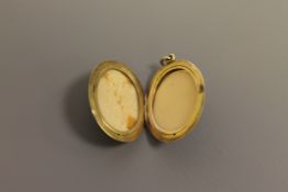 A large oval gold set memoriam locket, probably 14ct,
