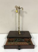 A set of portable brass pan scales with weights in a mahogany drawer