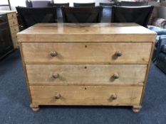 An antique pine three drawer chest with knob handles