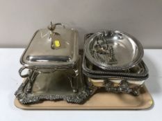 A tray of plated ware and food warmer on stand with burner
