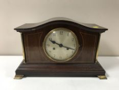 A Victorian inlaid mahogany mantel clock on brass feet
