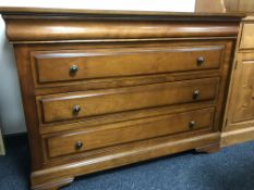 A contemporary four drawer chest in a walnut finish