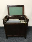 A mahogany storage piano stool containing a quantity of pianola rolls together with a box