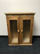 A pine double door glazed cabinet