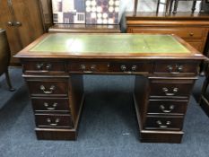 A twin pedestal desk inset green leather panel