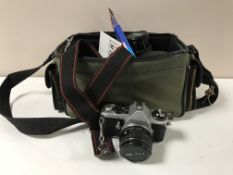 A camera bag containing a Pentax ME super camera with lenses and accessories
