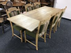 A blonde oak dining table with two leaves and six chairs