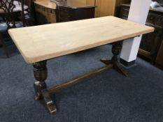 A carved oak refectory dining table with stripped top