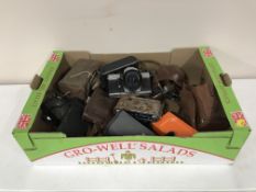 A box of vintage cameras including Zenit, Praktika,