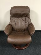 A late 20th century brown leather revolving armchair