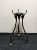 A mahogany tripod plant stand with brass feet and mounts