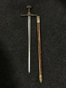 A longsword in scabbard with brass handle and pommel