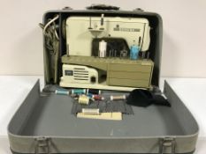 A Bernina electric sewing machine in case and a 8 mm projector