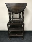 A heavily carved oak drop leaf table and an oak trolley