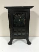 An early twentieth century oak mantel clock in the style of Liberty & Co