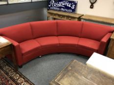 A late 20th century continental curved settee upholstered in red