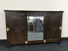 An early 20th century oak mirrored coat rack