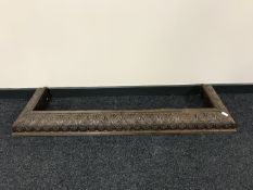 An early 20th century heavily carved oak fire curb