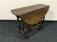 An antique oak drop leaf table fitted a drawer