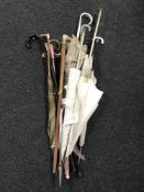 A bundle of Victorian style parasols, walking sticks, cane,