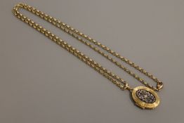 A 9ct gold enamelled locket on 9ct gold chain, 20.