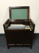 A mahogany storage piano stool containing a quantity of pianola rolls together with a box