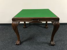 A mahogany baize top card table on claw and ball feet