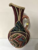 A pottery Persian jug decorated with wool and Hessian