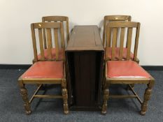 An oak drop leaf table and four rail back chairs