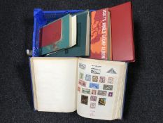 A basket of six assorted stamp albums containing stamps of the world