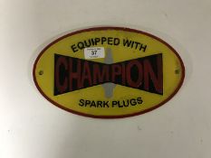 A cast iron Champion Spark Plugs plaque