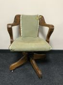 An early 20th century oak revolving office armchair,